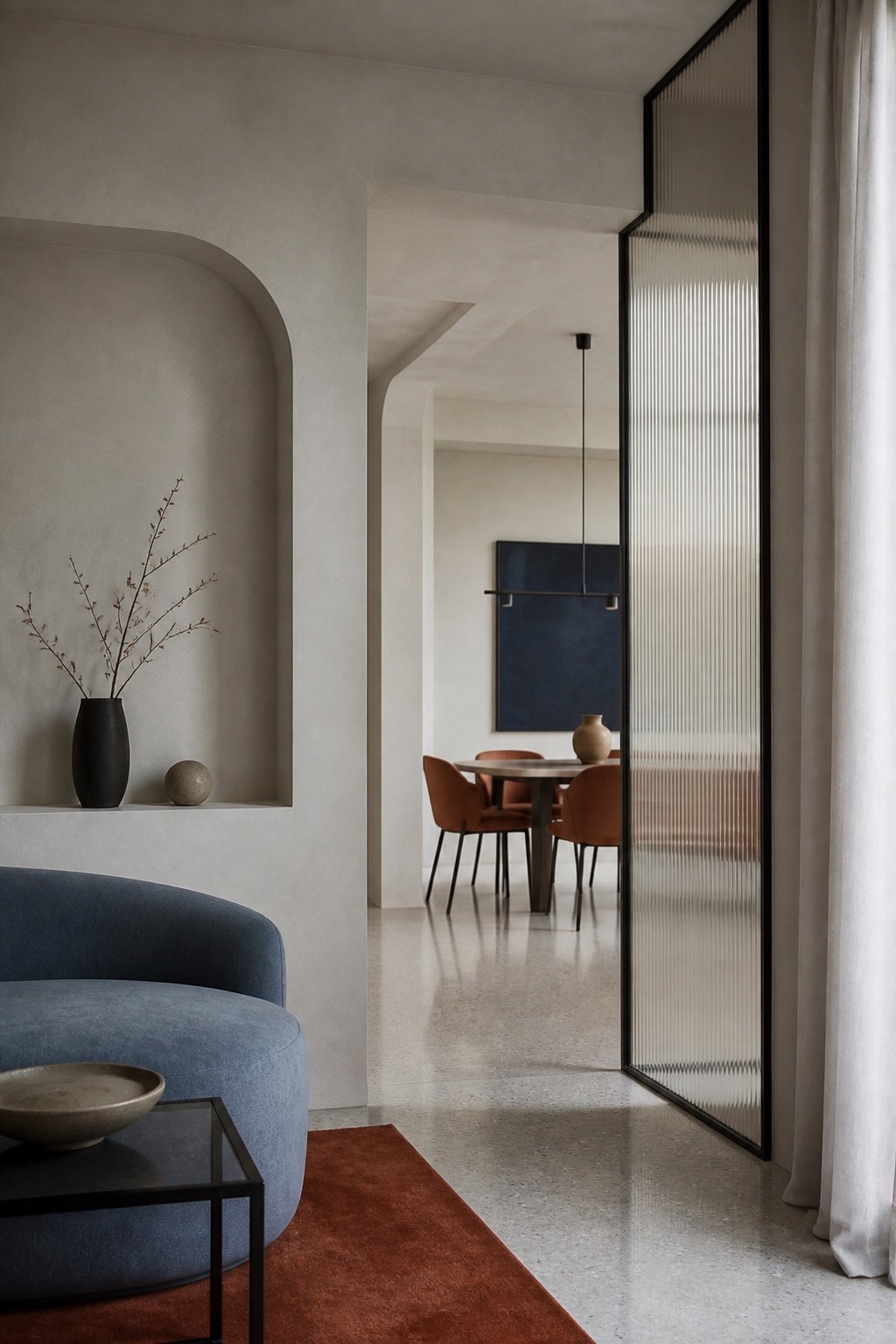 Mineral interior punctuated by blue textiles, glass and metal